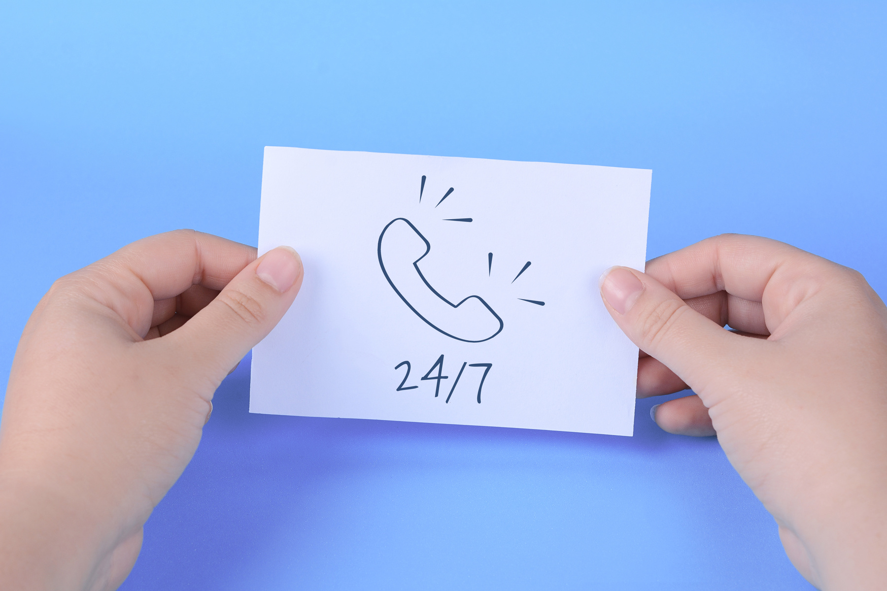 Woman's Hand Holding Card with Words "24/7"